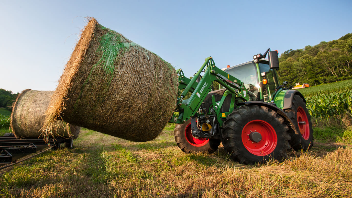 Fendt 500 Vario tractor hauling round hay bale