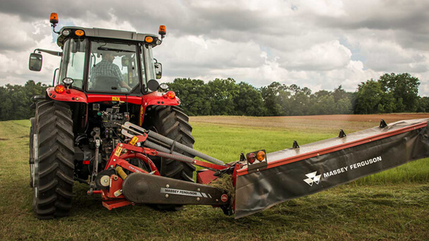Massey Ferguson Pro series disc mower with tractor in field close up