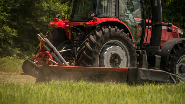 Massey Ferguson Pro series disc mower with tractor in field close up from the ground