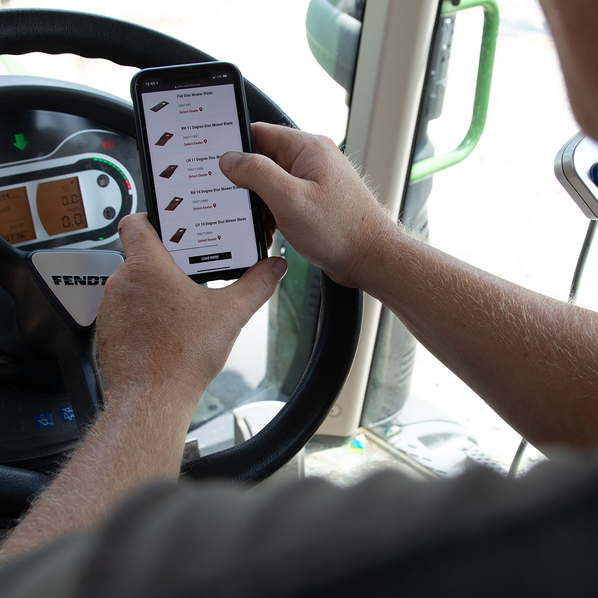 Phone in Fendt tractor looking at parts online.