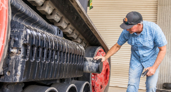 Track tractor with man inspecting tracks
